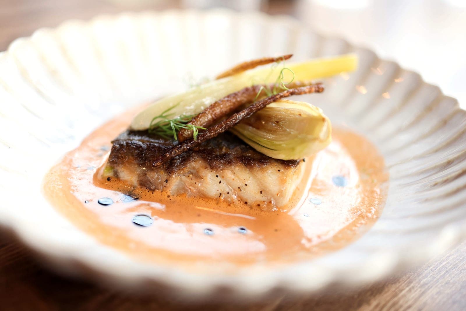 Roast sea bass with crisp skin and shaved fennel in a light sauce.